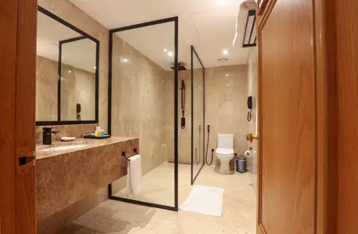 a bathroom with a shower and a sink and a toilet at Dubai Marine Beach Resort & Spa in Dubai