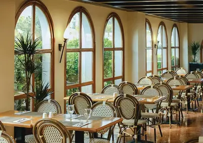 a dining room with tables and chairs and windows at Dubai Marine Beach Resort & Spa in Dubai