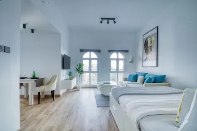 a white room with a bed and a couch and a desk at The Smart Concierge - Discovery Gardens street 4 in Dubai