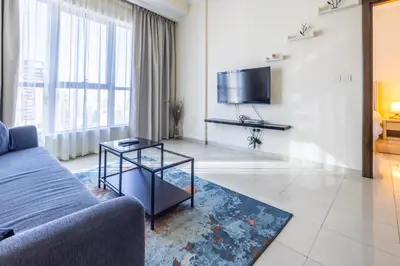 a living room with a couch and a tv at Awesome Marina Canal View 1BD Bay Central Marina in Dubai