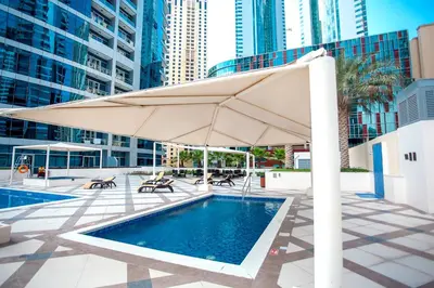 a large umbrella next to a swimming pool at Awesome Marina Canal View 1BD Bay Central Marina in Dubai