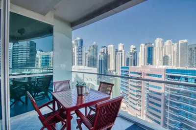 a table and chairs on a balcony with a view of the city at The Smart Concierge - Damac Waves in Dubai