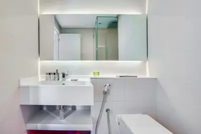 a white bathroom with a sink and a mirror at Stylish Studio in West Avenue Dubai Marina in Dubai