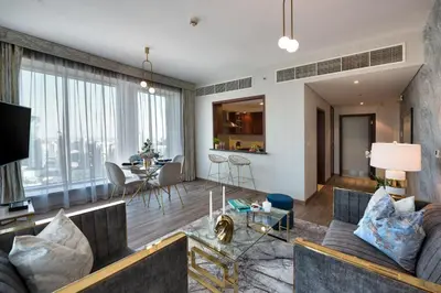 a living room with a couch and a table at Durrani Homes - Designer 2BR Apt with stunning Burj khalifa and Fountain View in Dubai