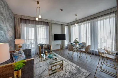 a living room with a table and chairs and a couch at Durrani Homes - Designer 2BR Apt with stunning Burj khalifa and Fountain View in Dubai