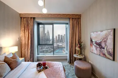 a hotel room with a bed and a large window at Durrani Homes - Designer 2BR Apt with stunning Burj khalifa and Fountain View in Dubai