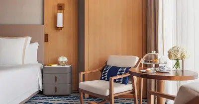 a hotel room with a bed and a table and chair at Jumeirah Beach Hotel Dubai in Dubai
