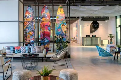 a lobby with a couch and chairs in a room at Rove La Mer Beach, Jumeirah in Dubai