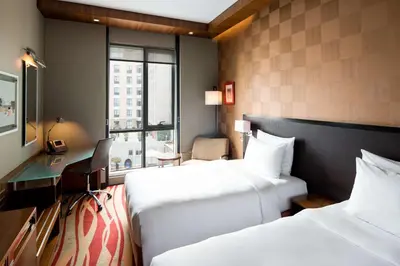 a hotel room with two beds and a desk at Radisson Blu Hotel, Dubai Media City in Dubai