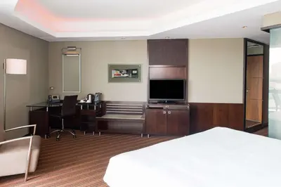 a hotel room with a bed and a desk with a television at Radisson Blu Hotel, Dubai Media City in Dubai