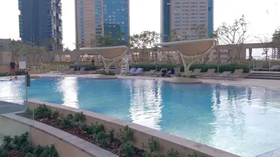 a large swimming pool in a city with tall buildings at FIRST CLASS 3BR with full BURJ KHALIFA and FOUNTAIN VIEW in Dubai