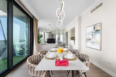a dining room with a white table and chairs at FIRST CLASS 3BR with full BURJ KHALIFA and FOUNTAIN VIEW in Dubai