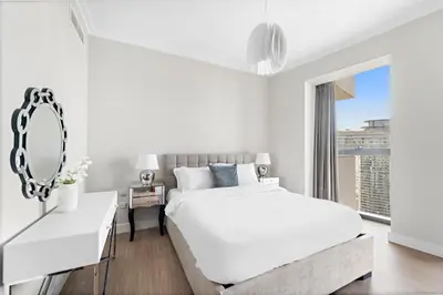 a white bedroom with a large bed and a mirror at FIRST CLASS 3BR with full BURJ KHALIFA and FOUNTAIN VIEW in Dubai