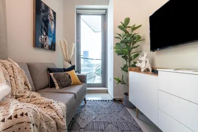 a living room with a couch and a tv at The Smart Concierge - Bay Central in Dubai