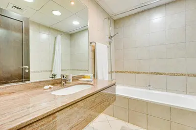 a large bathroom with a tub and a sink at Sea View Studio 10min from beach Royal Oceanic in Dubai