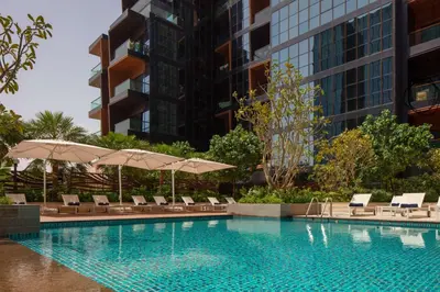 a swimming pool with lounge chairs and umbrellas at DoubleTree by Hilton Dubai M Square Hotel & Residences in Dubai