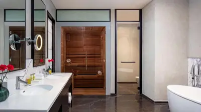 a bathroom with two sinks and a shower at DoubleTree by Hilton Dubai M Square Hotel & Residences in Dubai