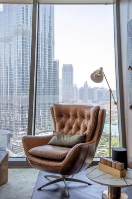 a brown leather chair in a room with a large window at Frank Porter - Burj Vista in Dubai