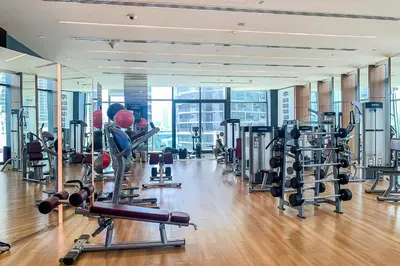 a gym with a lot of treadmills and machines at Frank Porter - Burj Vista in Dubai
