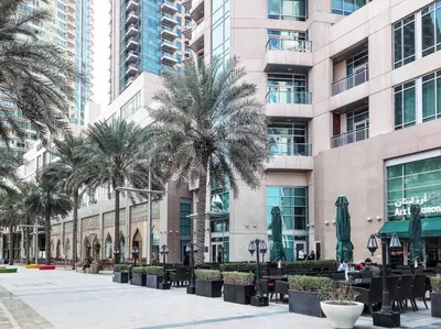 a building with palm trees and tables in front of it at Frank Porter - Burj Vista in Dubai