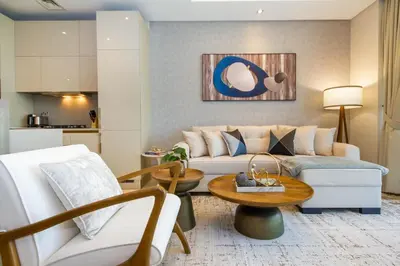 a living room with a couch and a table at Bespoke Holiday Homes - Palm Jumeirah- 2 Bedroom Sea View with Pool & Beach Access, The 8 in Dubai