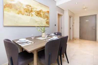 a dining room with a wooden table and chairs at Bespoke Holiday Homes - Palm Jumeirah- 2 Bedroom Sea View with Pool & Beach Access, The 8 in Dubai