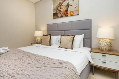 a bedroom with a large white bed and two lamps at Bespoke Holiday Homes - Palm Jumeirah- 2 Bedroom Sea View with Pool & Beach Access, The 8 in Dubai