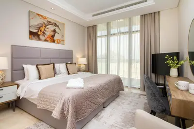 a bedroom with a bed and a desk and a television at Bespoke Holiday Homes - Palm Jumeirah- 2 Bedroom Sea View with Pool & Beach Access, The 8 in Dubai