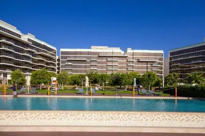 a swimming pool in front of two large buildings at Bespoke Holiday Homes - Palm Jumeirah- 2 Bedroom Sea View with Pool & Beach Access, The 8 in Dubai