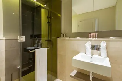 a bathroom with a sink and a shower at Bespoke Holiday Homes - Palm Jumeirah- 2 Bedroom Sea View with Pool & Beach Access, The 8 in Dubai
