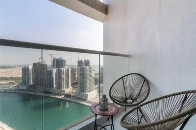 a balcony with two chairs and a view of the city at The Smart Concierge - Damac Prive in Dubai