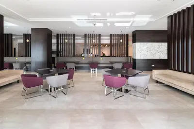 a lobby with tables and chairs and a bar at The Smart Concierge - Damac Prive in Dubai