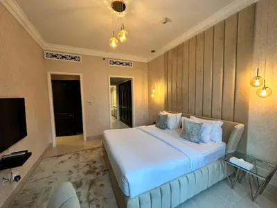 a bedroom with a large white bed and a television at Durrani Homes - Heaven On Earth- Burj Khalifa Fireworks in Dubai