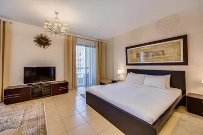 a bedroom with a large bed and a flat screen tv at Huge Sea View Studio in Murjan JBR in Dubai