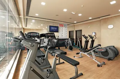 a gym with treadmills and elliptical machines at MENA ApartHotel Albarsha At The Mall in Dubai