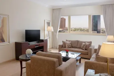 a living room with a couch and a tv at Grand Millennium Dubai in Dubai