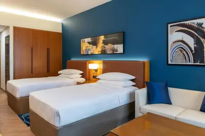 a hotel room with two beds and a couch at Four Points by Sheraton Bur Dubai in Dubai