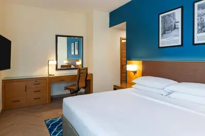 a bedroom with a bed and a desk with a mirror at Four Points by Sheraton Bur Dubai in Dubai