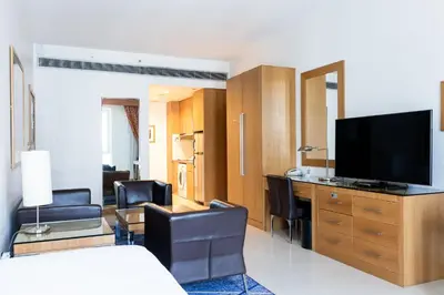 a hotel room with a television and a desk with chairs at Four Points by Sheraton Bur Dubai in Dubai