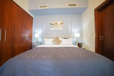 a bedroom with a large bed and two lamps at Modern 2BR with Balcony Sea Views and Pool, Gym Near Attractions in Dubai