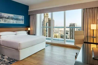 a bedroom with a large bed and large windows at Four Points by Sheraton Sheikh Zayed Road in Dubai