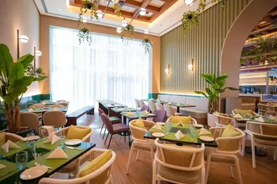 a restaurant with tables and chairs and a large window at Four Points by Sheraton Sheikh Zayed Road in Dubai