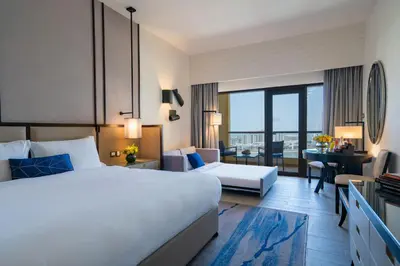 a hotel room with a bed and a desk at Amwaj Rotana, Jumeirah Beach - Dubai in Dubai