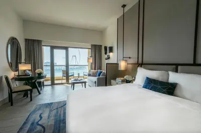 a bedroom with a large bed and a living room at Amwaj Rotana, Jumeirah Beach - Dubai in Dubai