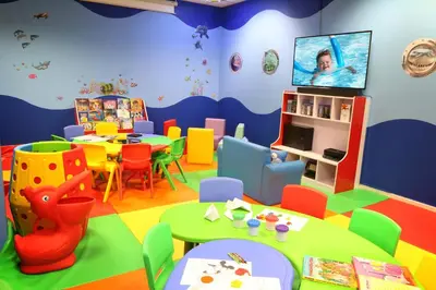 a kindergarten room with a table and chairs and a tv at Amwaj Rotana, Jumeirah Beach - Dubai in Dubai