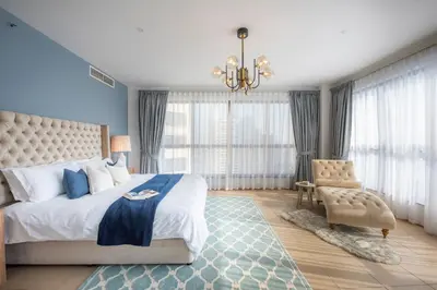 a bedroom with a large bed and a chair at Nasma Luxury Stays- Majestic Marina Views, Lavish 4BR Getaway in JBR in Dubai