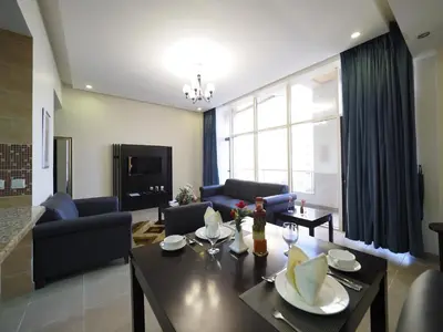 a living room with a table and chairs and a living room at Skylark Hotel Apartments AL Barsha in Dubai