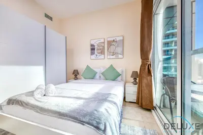a bedroom with a bed and a large window at Next to Lake 2BR Apartment Accessible to Metro, Dubai Gate 2, Jumeirah Lake Towers by Deluxe Holiday Homes in Dubai