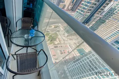 a glass table and chairs on top of a building at Next to Lake 2BR Apartment Accessible to Metro, Dubai Gate 2, Jumeirah Lake Towers by Deluxe Holiday Homes in Dubai