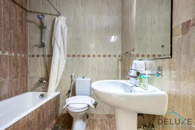 a bathroom with a sink and a toilet and a bath tub at Next to Lake 2BR Apartment Accessible to Metro, Dubai Gate 2, Jumeirah Lake Towers by Deluxe Holiday Homes in Dubai